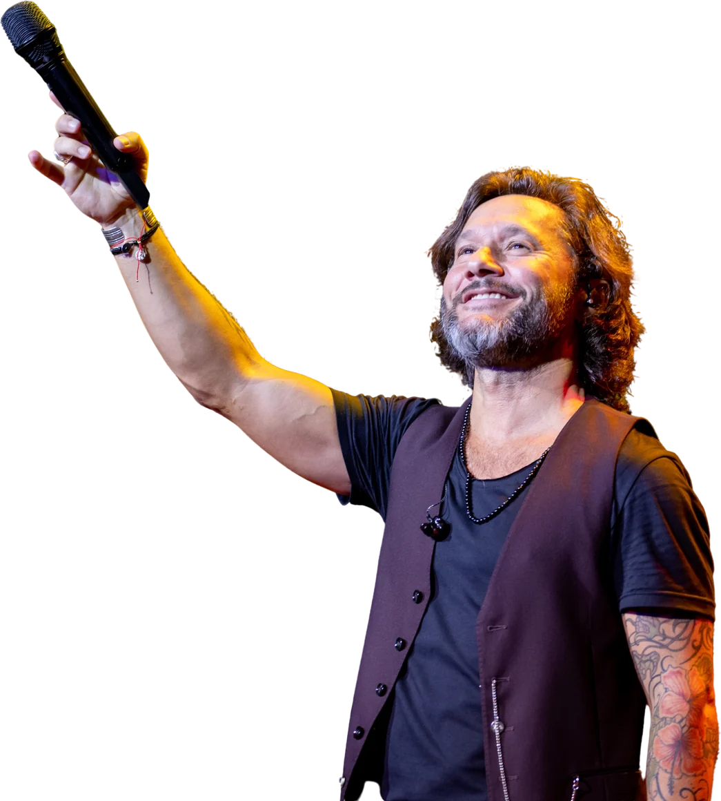 Diego Torres en escena, con el micrófono en alto.